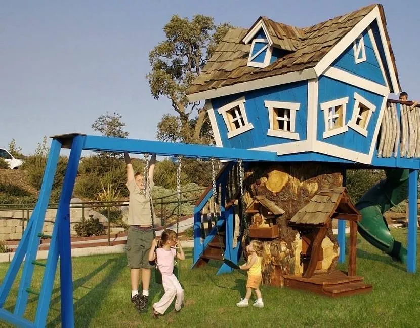 Детский дом на спиленном срубе дерева со «встроенными» качелями