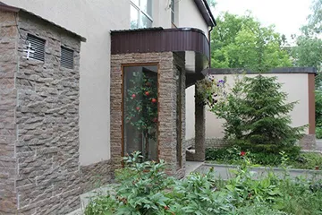 Цоколь дома, отделанный бетонным сайдингом