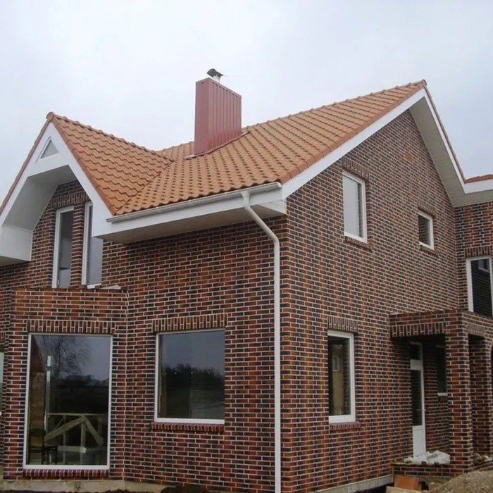 Дом, облицованный разноцветным керамическим материалом с белыми швами