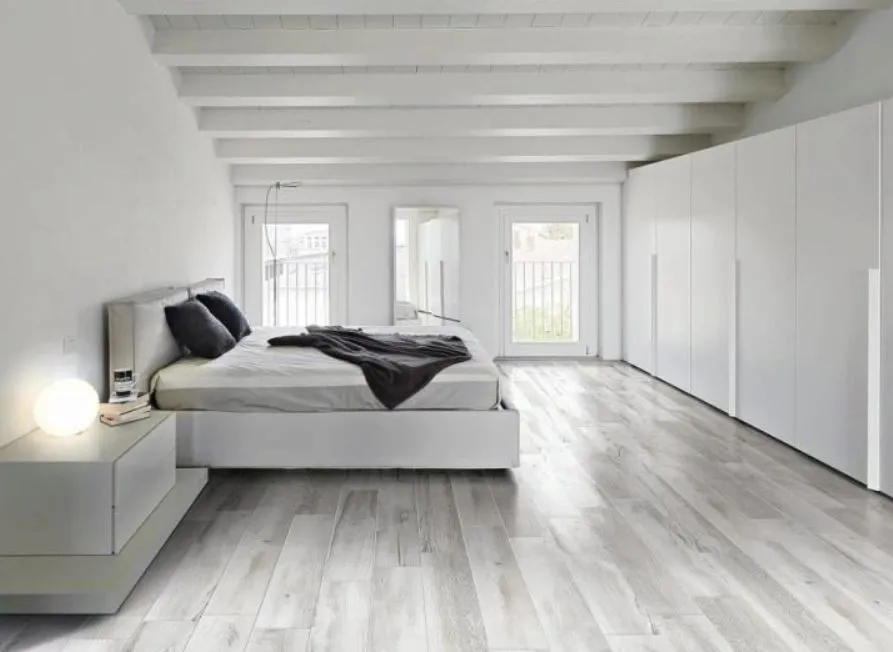 Серый пол и белые стены в интерьере большой спальни