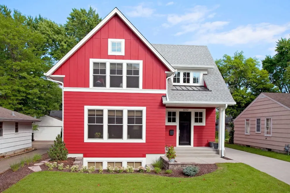 Красный фасад частного загородного дома отлично сочетается с белыми окнами