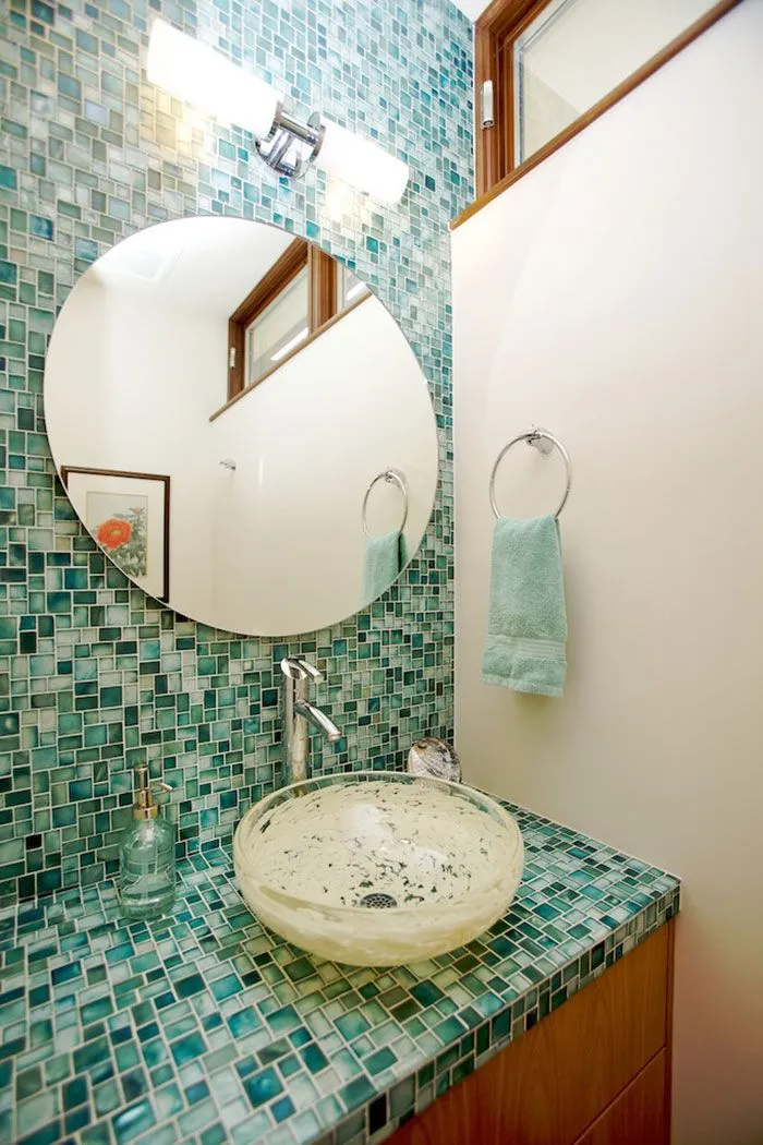 Мозаика изумрудной расцветки выбрана в качестве главного акцента ванной комнаты