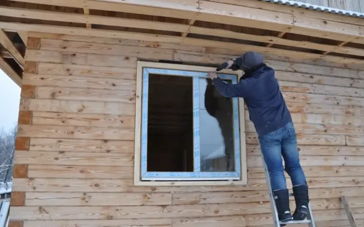 На фото крепление стеклопакета в доме под усадку