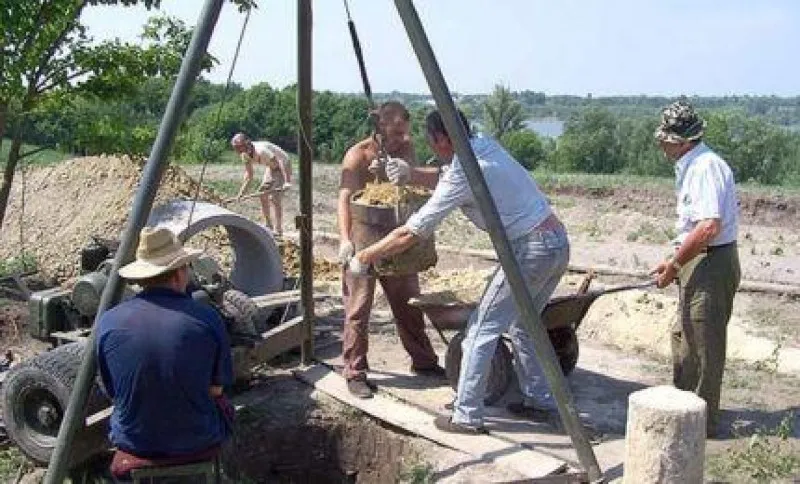 Использование треноги для опускания колец в колодец